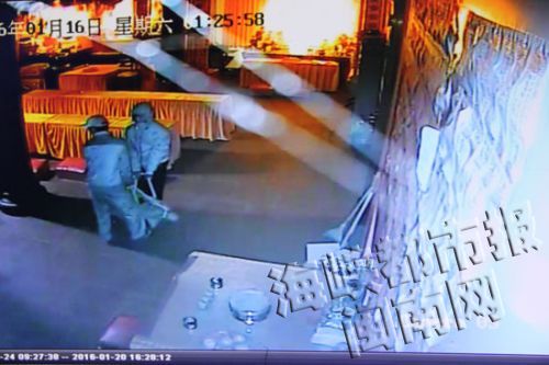 视频显示,2名戴着帽子的小偷抬着古佛像运走